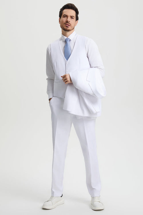 White Stacy Adams suit: two-button jacket, fitted vest with pockets, matching trousers. Lightweight, glossy fabric. Man holding jacket. Light blue tie completes the look.
