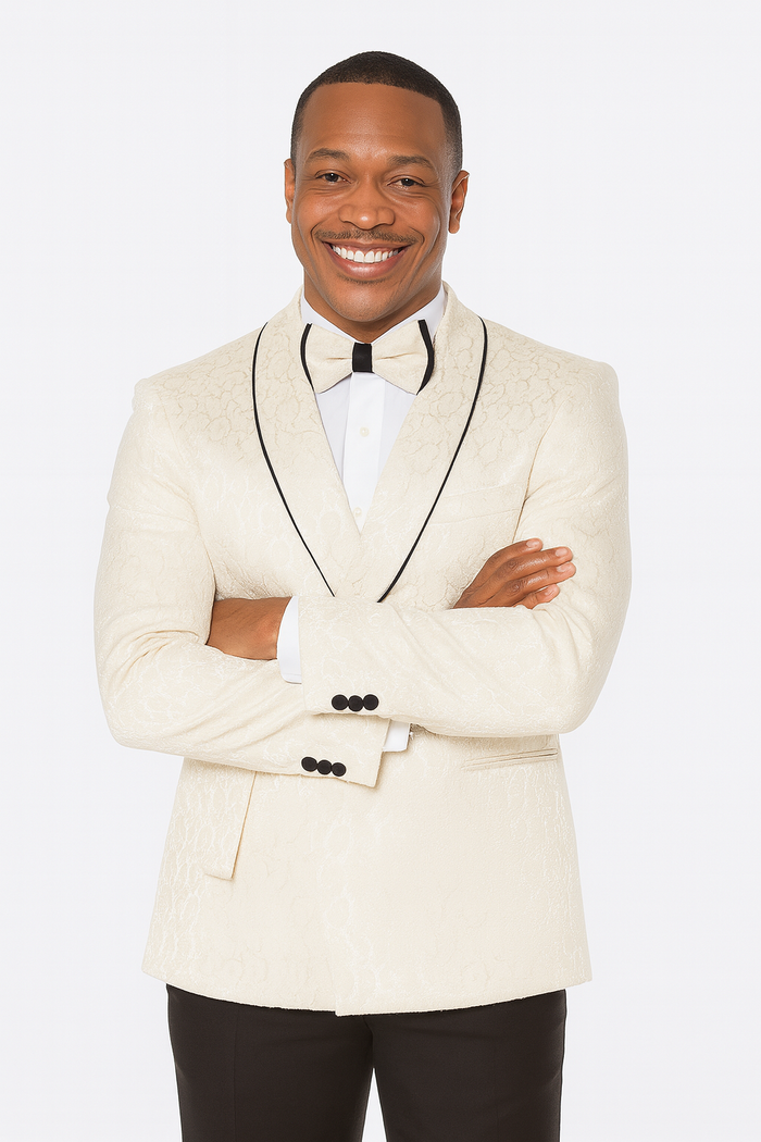 Men's champagne wedding tuxedo. Three-piece suit with light beige paisley. Jacket: notch lapel, black piping, and cuff buttons. Matching trousers.
