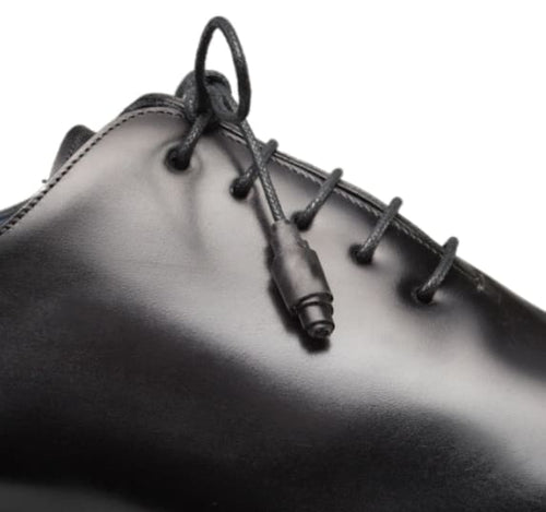 Black calfskin balmoral with rounded toe, smooth leather upper and sleek profile. Features black laces, eyelets, and defined edge stitching for a streamlined look.

