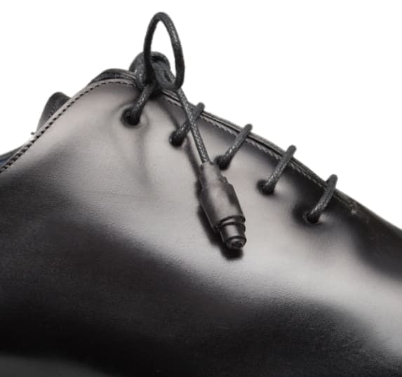 Black calfskin balmoral with rounded toe, smooth leather upper and sleek profile. Features black laces, eyelets, and defined edge stitching for a streamlined look.
