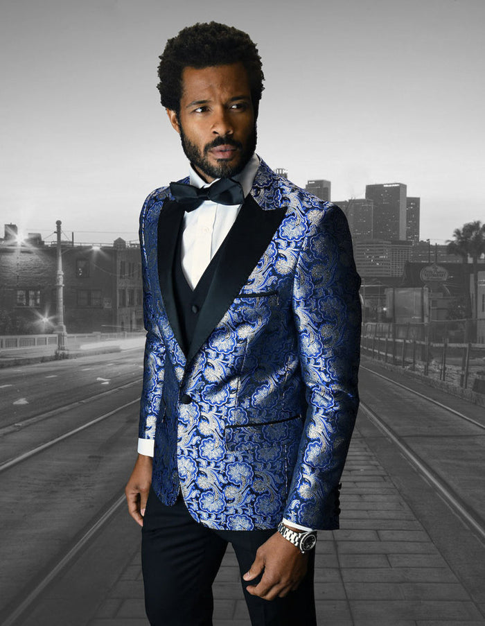 Royal blue & gold floral tuxedo for men. Features a one-button closure, peak lapel, and a textured fabric with a smooth finish. Includes a vest.
