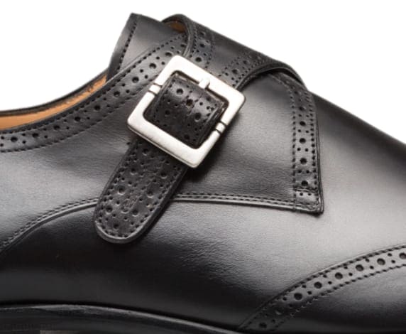 Black leather Forest oxford shoes with perforated edges and a silver buckle. Wingtip design.

