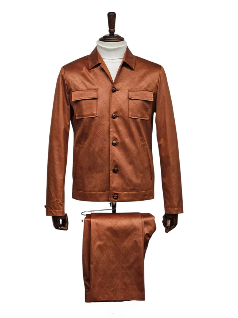 Men's brown faux leather slim-fit suit. Features a jacket with collar, chest pockets, and button closure, plus matching trousers. Quilted pattern adds texture. Sleek, coordinated look.
