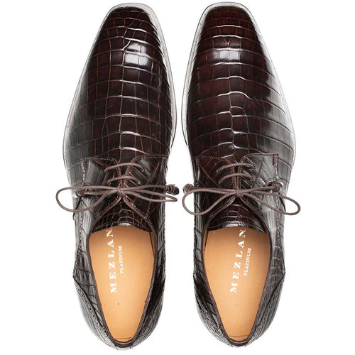 Mezlan men's brown alligator derby shoes. Glossy, pointed-toe, lace-up design with a distinct alligator skin pattern. Leather soles and light-colored insoles with the brand name.
