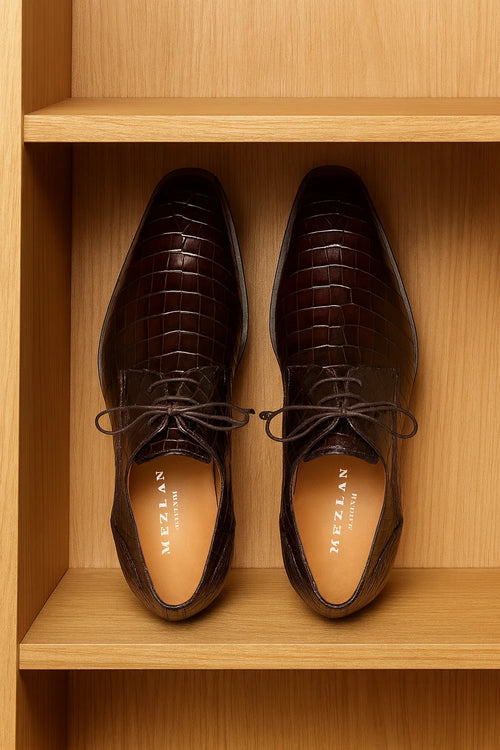 Men's brown alligator derby shoes. Pointed toe, lace-up vamp. Dark brown alligator leather upper with a raised pattern. Separate sole. Tan leather lining, branded insole.

