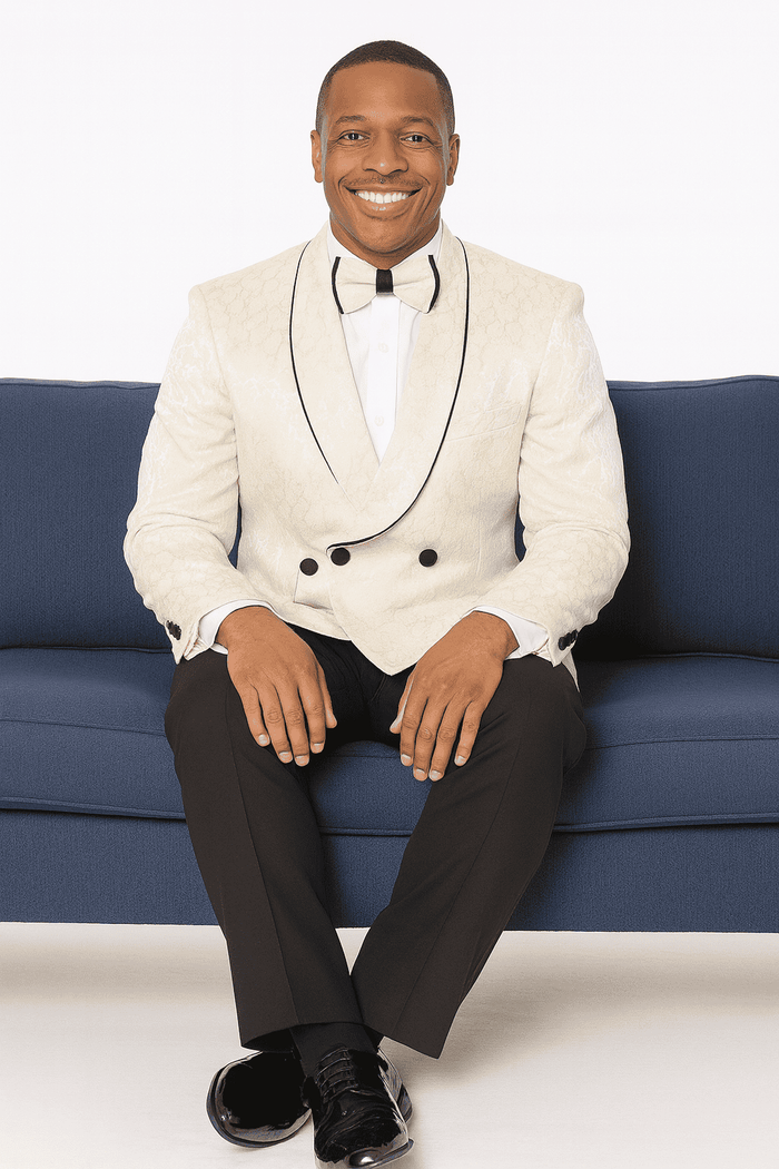 Cream paisley double-breasted tuxedo with black lapels and buttons. Includes black slim-fit trousers, white shirt, and black bow tie. Tailored fit for prom or wedding.
