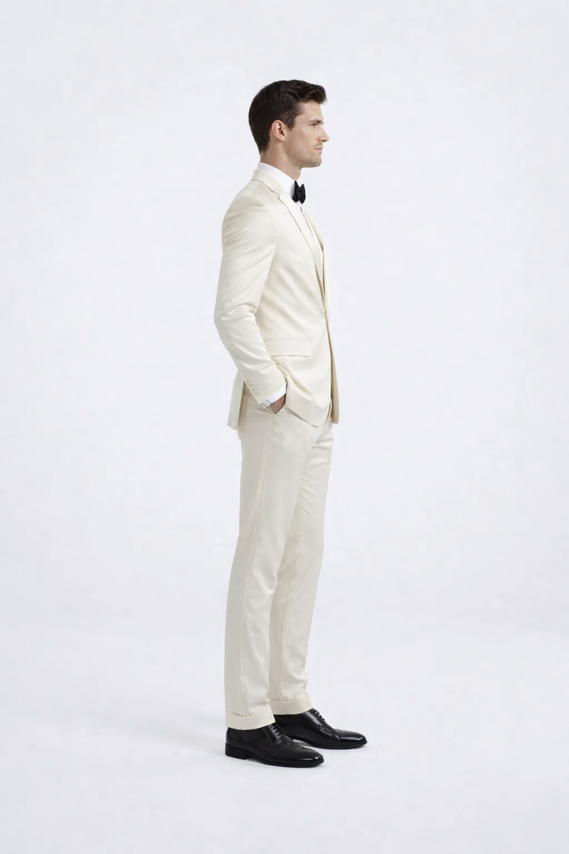 Ivory peak lapel slim fit tuxedo. Single-breasted, tailored silhouette. Lightweight, smooth fabric in solid ivory. Jacket features peak lapel, paired with matching slim-fit trousers.
