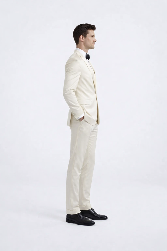 Ivory peak lapel slim fit tuxedo. Single-breasted, tailored silhouette. Lightweight, smooth fabric in solid ivory. Jacket features peak lapel, paired with matching slim-fit trousers.
