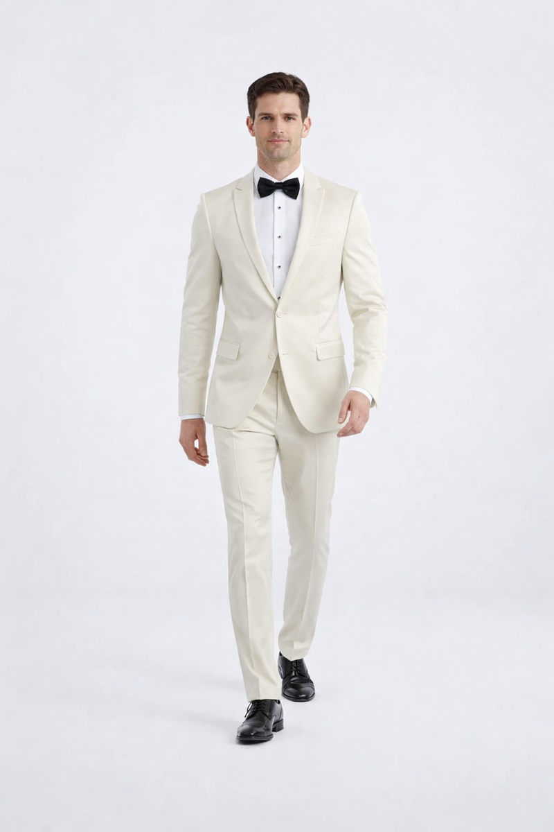 Ivory peak lapel slim fit tuxedo. Fitted silhouette, structured design, smooth ivory fabric. Single-breasted jacket, peak lapel, button closure, two pockets. Straight-leg trousers. Includes white shirt, black bow tie.
