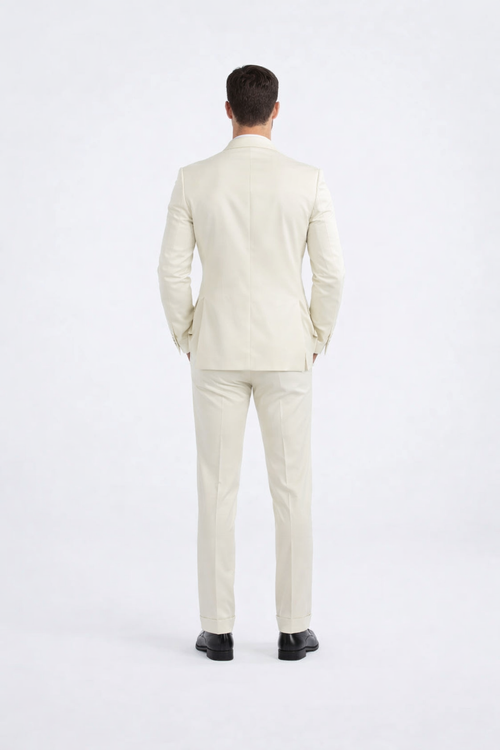 Ivory peak lapel slim fit tuxedo with tailored silhouette and structured back. Features matching ivory jacket and slim-fit pants in smooth, formal fabric. Perfect tuxedo design.
