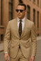 Light khaki cotton suit: tailored jacket (two-button, notch lapels, side pockets) & trousers. Fitted shape, smooth cotton. Dark brown patterned tie completes the ensemble.
