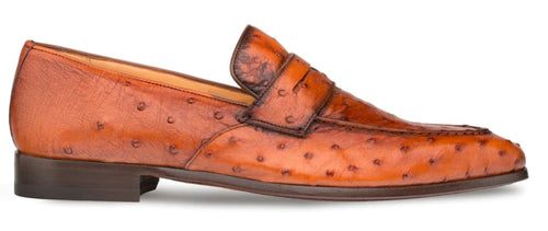 Mezlan's Lisbon Brandy Slip-On: Textured ostrich leather upper in warm brown. Rounded toe, stitched midfoot strap. Low wooden heel, smooth interior. Classic slip-on style.
