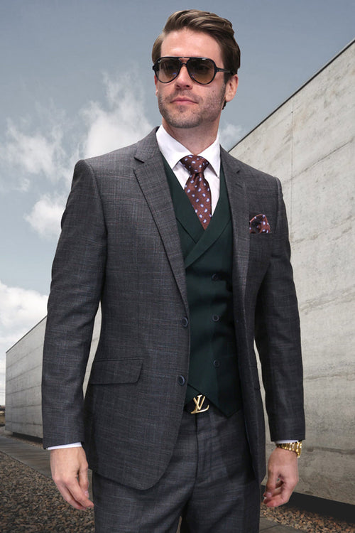 Hunter green wool designer suit with double-breasted vest, structured fit, sharp lapels, and button closures. Features a tailored design with subtle sheen. Includes contrasting patterned tie and pocket square in brown tones.
