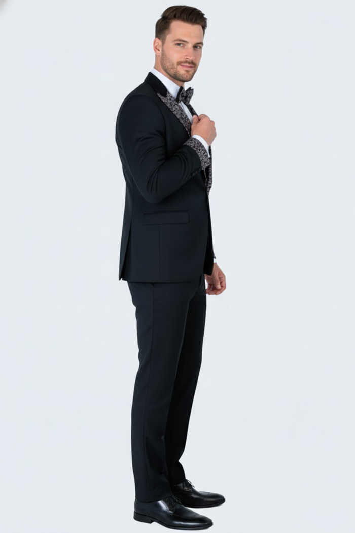 Men's black tuxedo suit with white embellished lapels & bow tie. Tailored jacket, slim-fit trousers. Includes black shoes.
