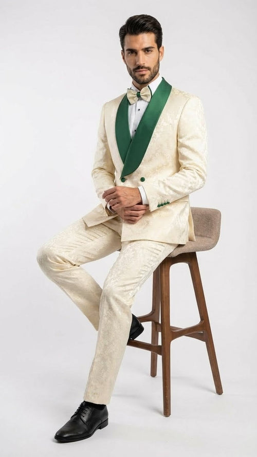 Ivory and emerald green men's jacquard tuxedo suit. Fitted jacket with green shawl lapel and decorative buttons. Slim-fit pants. Intricate pattern.
