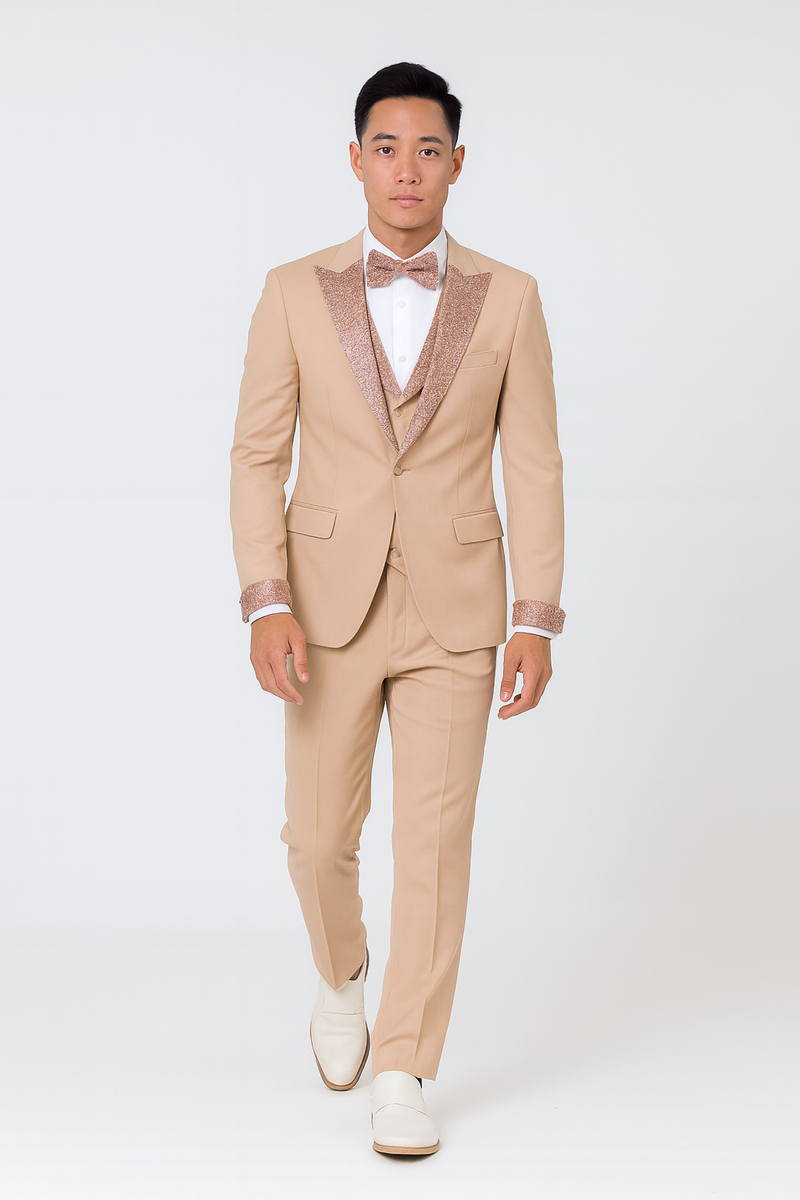 Men's champagne rose gold prom tuxedo: tailored jacket w/ rose gold glitter lapel, matching trousers. Single-button jacket, white shirt, rose gold bow tie. White footwear contrasts the champagne ensemble.
