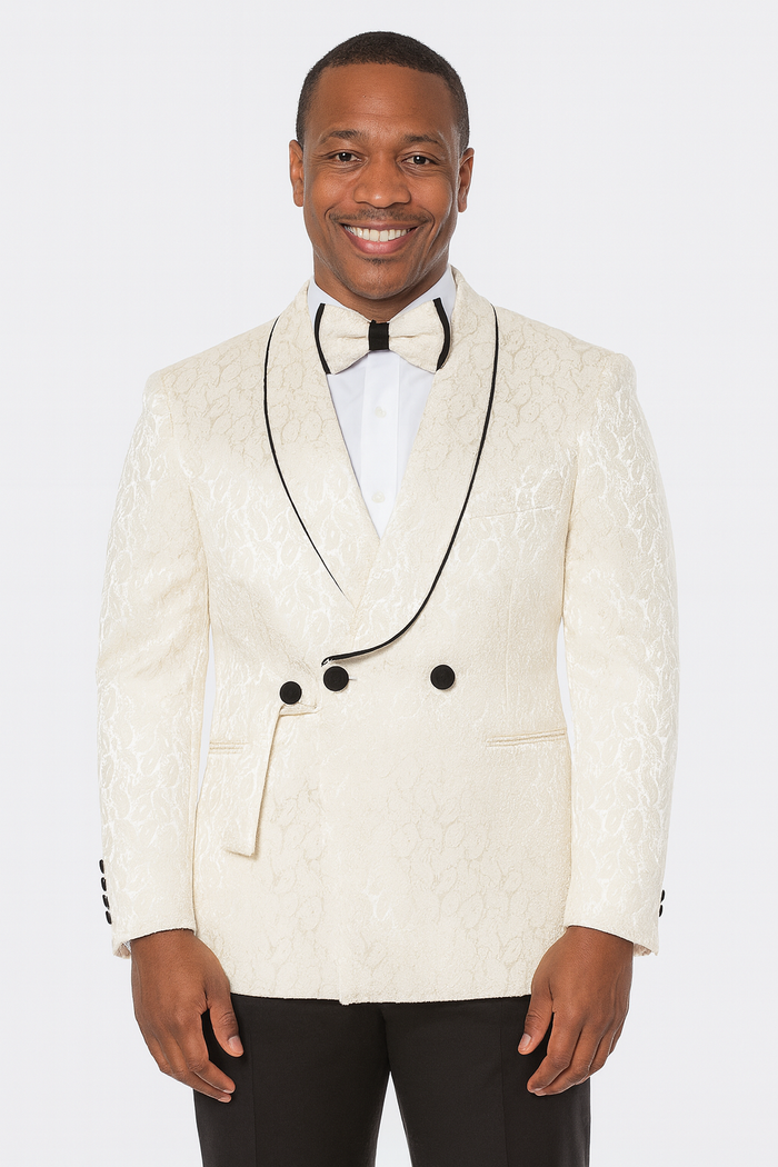 Men's champagne wedding tuxedo: three-piece suit with paisley pattern. Double-breasted jacket, shawl lapel, black piping, textured champagne fabric, black buttons. Black trousers, matching bow tie.
