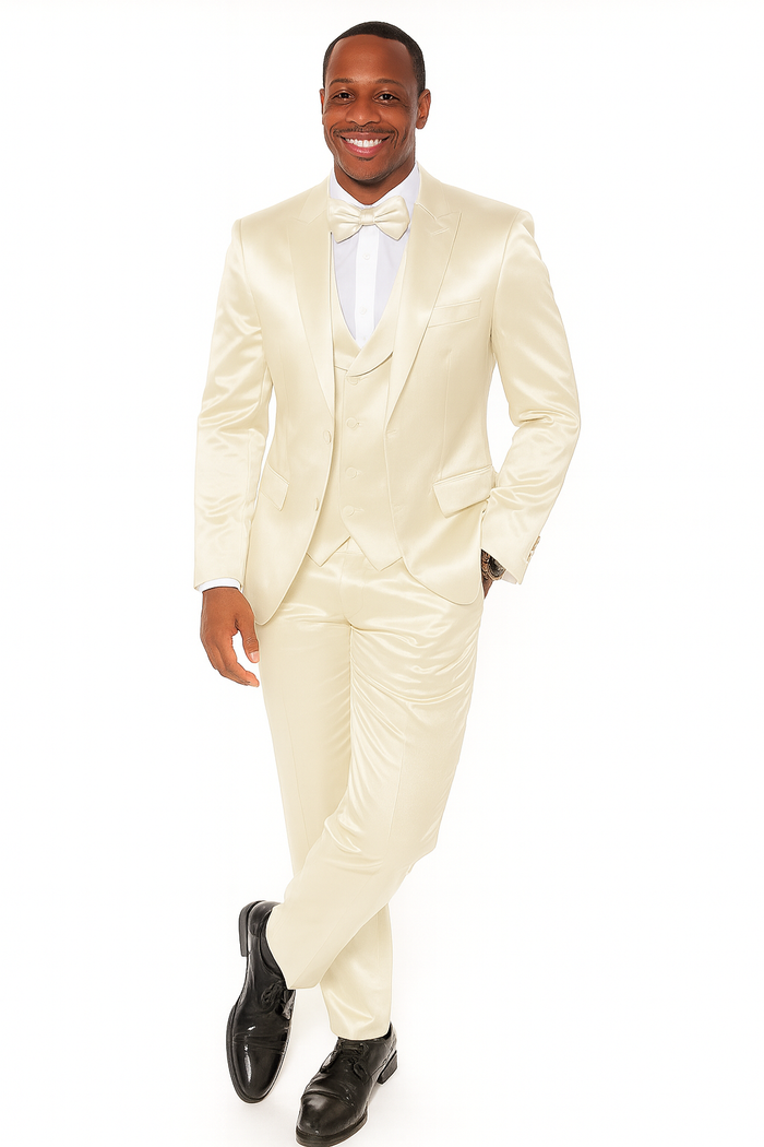 Men's champagne satin tuxedo set: single-breasted jacket, waistcoat, straight-leg trousers. Includes bow tie & white shirt. Smooth satin finish. Styled with front pockets, black dress shoes. Formal attire.
