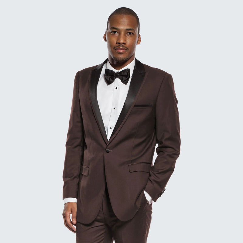 Chocolate brown tuxedo with black satin peak lapel. Single-breasted, well-fitted. Includes white dress shirt & black bow tie. Smooth fabric with subtle sheen.
