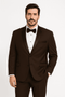 Chocolate brown men's tuxedo with black satin peak lapel. Single-button closure, two pockets, and tailored fit. Made of smooth fabric. Classic formal wear.
