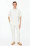 Men's linen two-piece set: white banded collar short-sleeve shirt with two front pockets and button closures, plus slim-fit pants.
