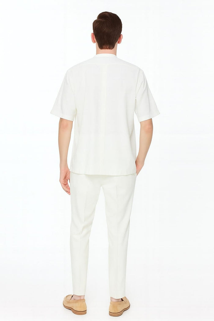 Men's linen two-piece set featuring a short-sleeve, banded collar shirt and matching slim-fit pants. Crafted from linen for consistent color and texture, offering a relaxed yet tailored look.
