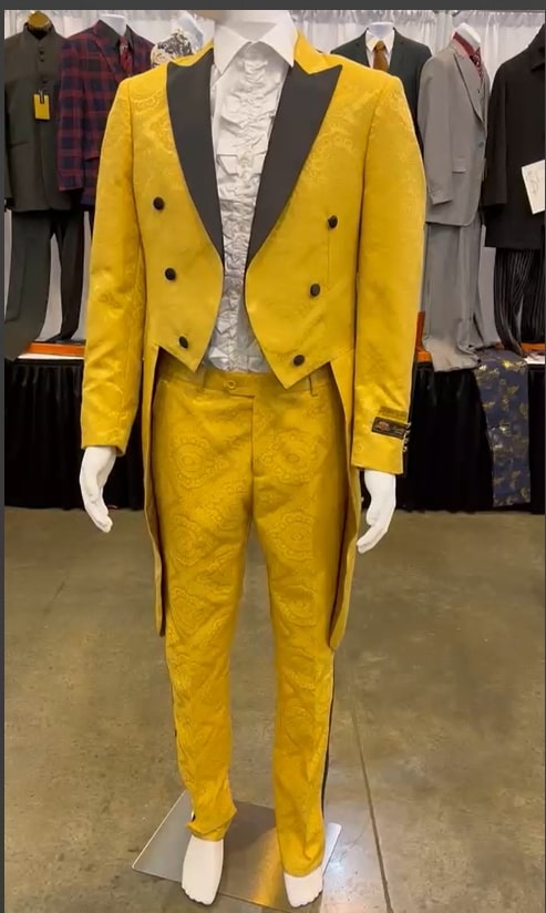 Yellow tailcoat tuxedo with black lapel & brocade detailing on jacket & pants. Structured, vintage-style jacket (double-breasted). Fitted trousers with classic design.
