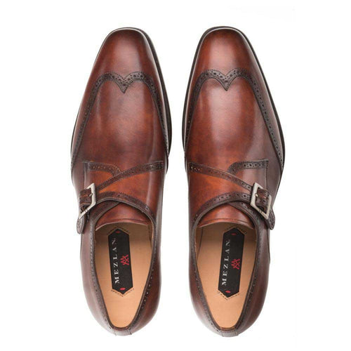 Mezlan Forest men's monk straps: cognac calfskin, wingtip design. Double buckle, broad vamp, decorative broguing. Elongated, pointed toe. Rich cognac color with tonal gradient.
