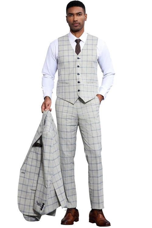 Grey-blue Stacy Adams one-button suit. Windowpane plaid pattern. Peak lapel vest with 5 buttons, notched collar. Slim-fit trousers. Lightweight, woven fabric. Suit jacket in hand.