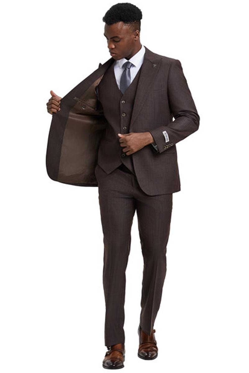 Brown windowpane plaid suit. One-button blazer with wide peak lapel, vested with three buttons. Smooth lining, slim-fit trousers. Tailored for a fitted look.
