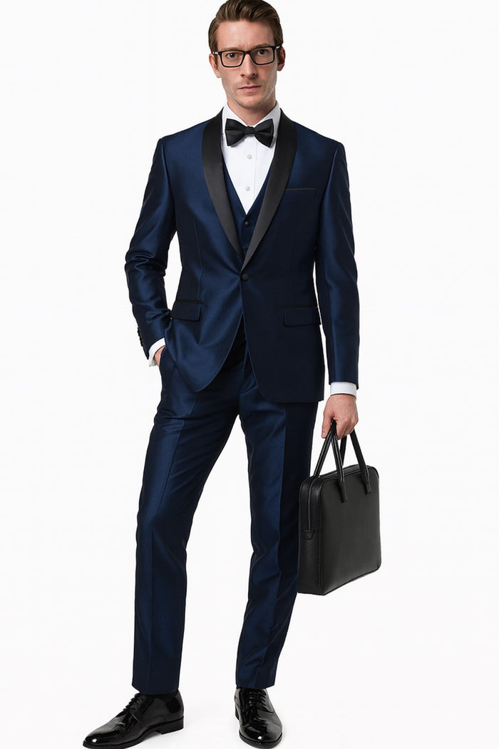 Men's navy blue satin tuxedo with black shawl lapel. Three-piece suit: jacket, matching vest, and sapphire blue trousers. Single-button jacket closure, smooth trouser finish.
