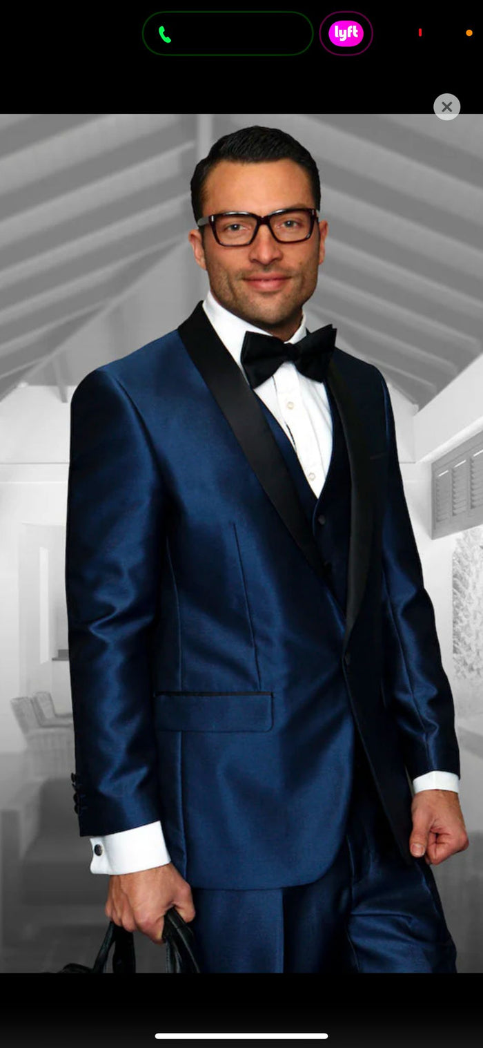 Navy satin tuxedo with black shawl lapel. Three-piece design in sapphire blue. Elegant and refined.
