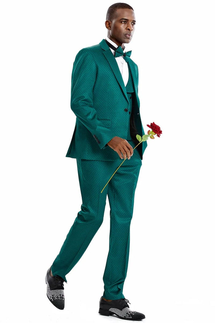 Men's green suit with black polka dots. Includes a one-button blazer, matching vest, and tailored pants. Features a structured blazer with notch lapels, a straight-cut trouser, and a black bow tie. Smooth, slightly shiny fabric.

