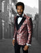 Red floral one-button tuxedo with peak lapel. Features a shiny, textured pattern, tailored sleeves with white cuffs, and a black vest. Paired with black trousers.
