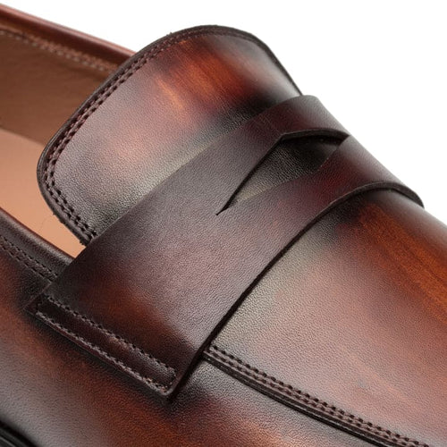 Mezlan's Men's Avenue penny loafers in cognac/rust leather. Features include a vamp strap, rounded toe, subtle stitching, and a contrasting black sole.
