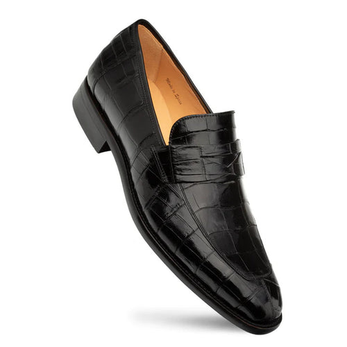 Black alligator penny loafer. Elongated shape, rounded toe, raised vamp. Prominent scale pattern, stitched strap. Low stacked heel. Tan interior lining.
