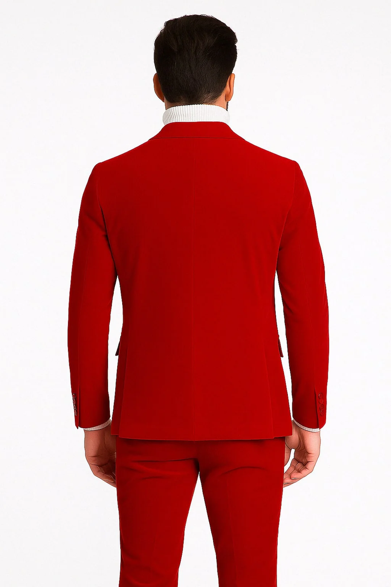 Men's slim-fit red velvet suit. Double-breasted with peak lapels. Smooth texture, tailored silhouette. Jacket: two back vents, buttoned cuffs. Monochromatic red.
