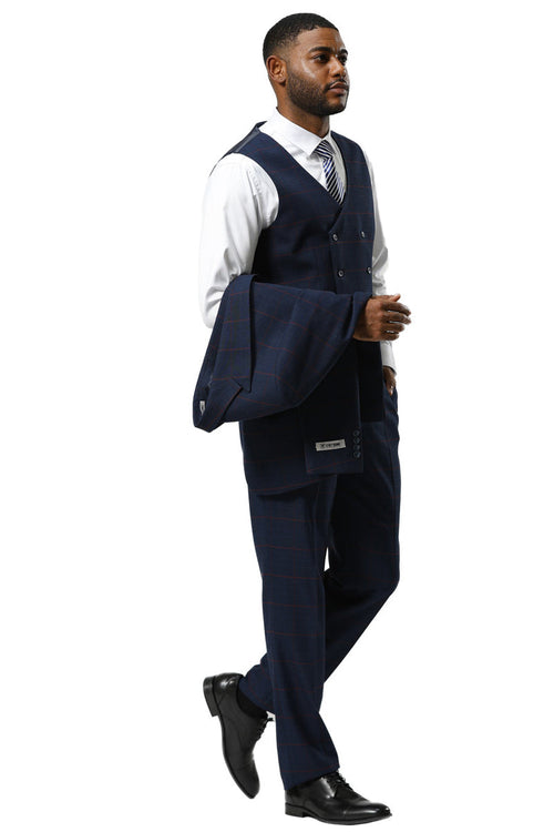 Navy glen plaid Stacy Adams suit with a one-button peak lapel. Features a double-breasted vest and tailored trousers. Includes a textured fabric, with a dress shirt and patterned tie visible. Jacket held over the arm.
