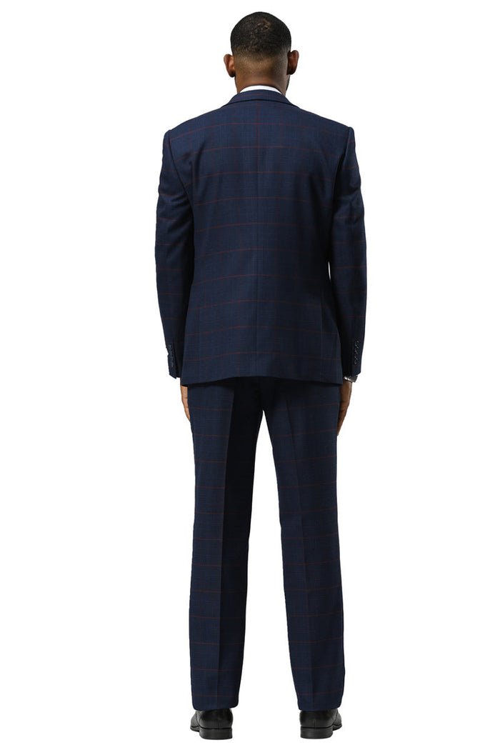 Navy glen plaid suit: one-button peak lapel jacket, structured fit, flat-front trousers. Navy/red check pattern. Single vent jacket, double-breasted vest. Classic, tailored look.
