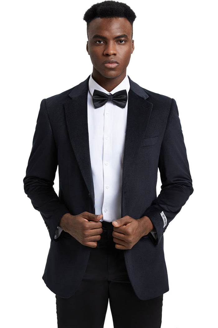 Black velvet blazer with a modern fit, featuring a single-breasted design, notch lapels, and front flap pockets. The internal lining is not visible.