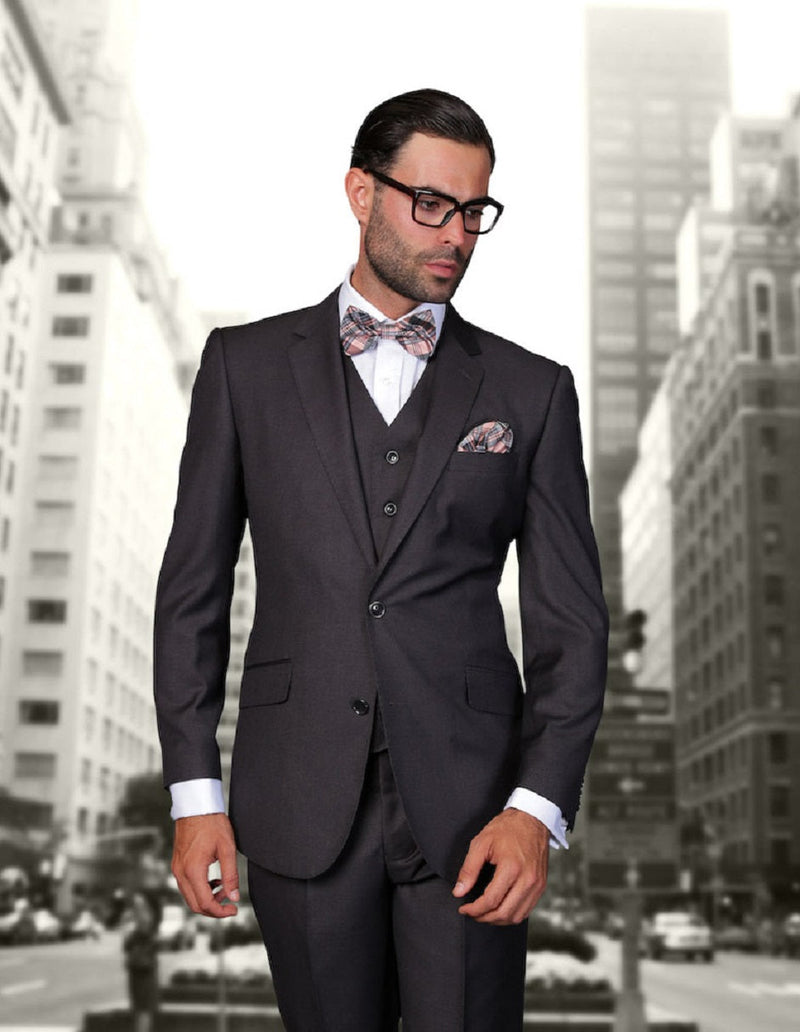 Heather charcoal modern fit men's vested wool suit. Tailored jacket with notched lapel, two pockets, and matching vest. Textured wool fabric, dark gray with subtle variations. Patterned bow tie and pocket square. Structured fit.
