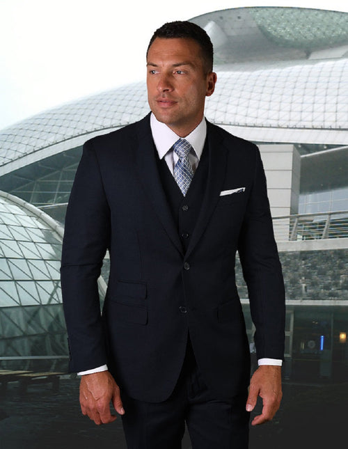 Men's modern fit navy blue vested suit with pick stitching. Features a structured, tailored blazer with notch lapels and dual pockets. Vest included for a cohesive look. Slight fabric sheen.
