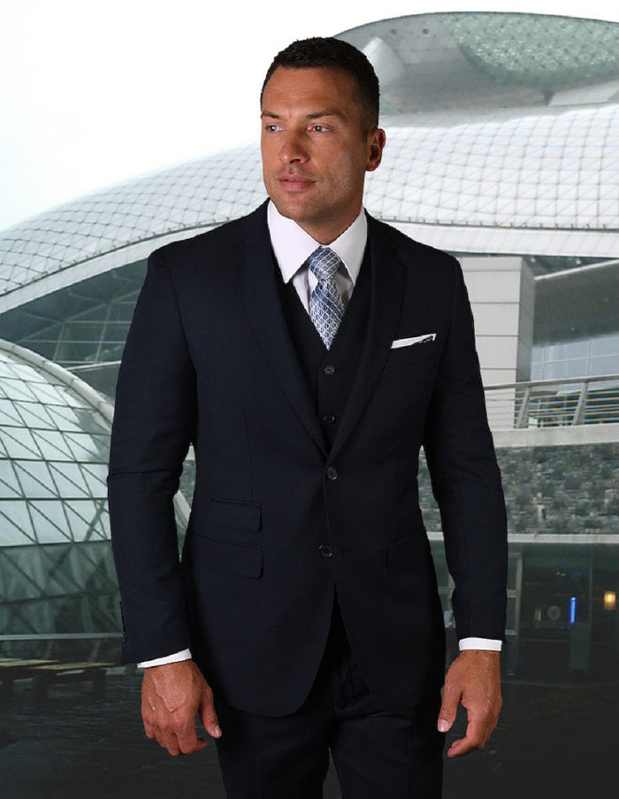 Men's modern fit navy blue vested suit with pick stitching. Features a structured, tailored blazer with notch lapels and dual pockets. Vest included for a cohesive look. Slight fabric sheen.
