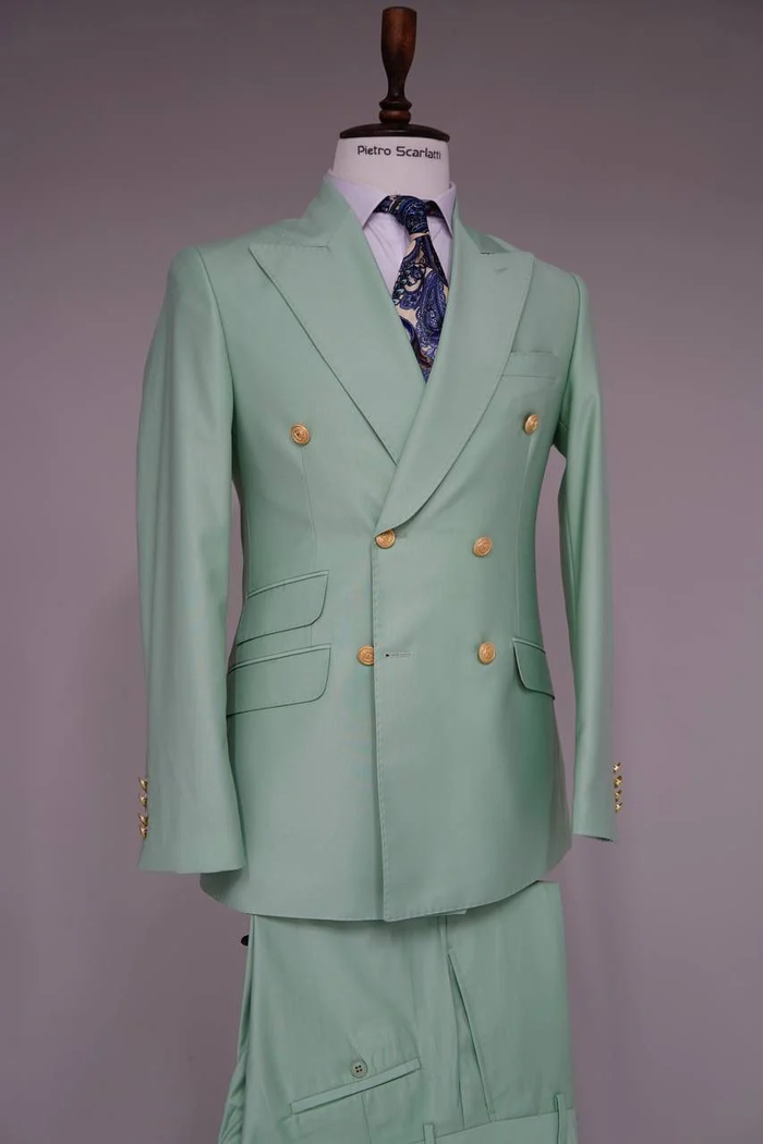 Sage green double-breasted men's suit. Features gold buttons, tailored fit, peak lapel, side pockets, and matching trousers. Elegant and stylish.
