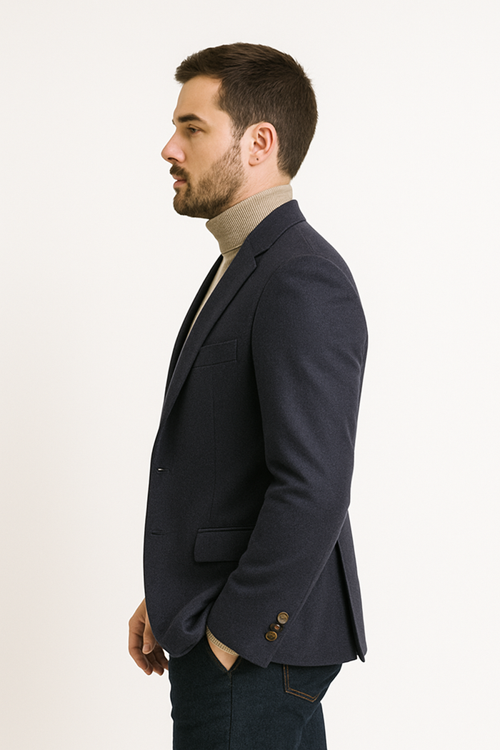 Navy cashmere men's jacket with notch lapel. Two-button closure, structured silhouette. Features a chest and two side pockets. Three-button cuff detail. Smooth, solid navy fabric.
