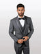 Mens charcoal vested tuxedo features a shawl lapel and bowtie, constructed from sleek fabric. The suit displays structured, tailored form with a three-button front and a fitted silhouette.