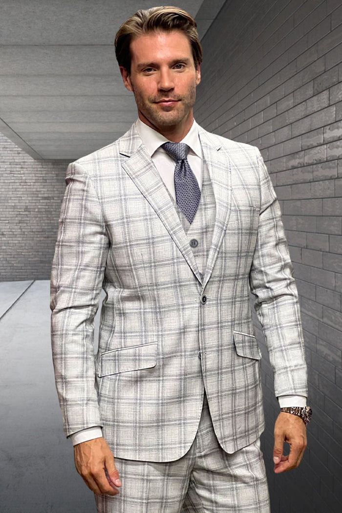 Tan wool suit with double windowpane plaid. Fitted blazer: notch lapels, 3-button closure. Matching vested trousers. Light tan base, darker tan checks. Designer menswear.
