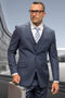 Charcoal grey men's designer suit with windowpane pattern. Tailored two-button jacket, fitted vest, and matching trousers. Fine wool blend for a structured, cohesive look.
