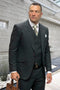 Men's hunter green wool suit. Windowpane plaid, peak lapel, three-piece design with vest. Smooth texture, fitted silhouette, maroon buttons. Two front pockets on jacket.
