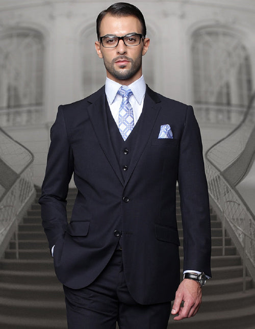 Navy blue men's wool suit with a classic fit. Two-button jacket with pleated pants. Features include a light blue tie, pocket square, and tailored silhouette.
